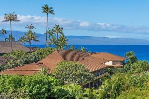 a house on a hill with palm trees and the ocean at Maui Kaanapali Villas 415 · MKV 415 Updated Condo w Ocean View a in Kahana