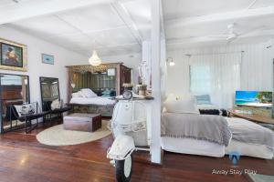 a room with a scooter parked in front of a bedroom at Shellies On The Beach - Big House in Sawtell +61 photos