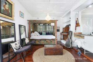 a bedroom with a bed and a piano at Shellies On The Beach - Big House in Sawtell