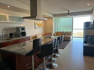 a kitchen and living room with a table and chairs at Beachfront Apartment in Mazatlán
