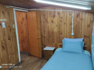 a bedroom with a bed and a wooden wall at Hospedaje Mirador del Puerto in Quellón +41 photos