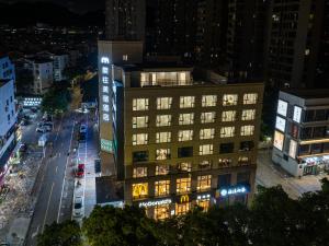 Un edificio iluminado en una ciudad por la noche. en 象往酒店一情侣路海滨泳场店, en Zhuhai 24 fotos más
