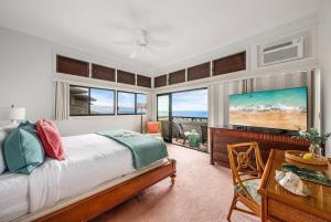 a bedroom with a bed and a desk and windows at Kapalua Ridge Villas 1011 · KRV 1011 Oceanview Condo + Golf + Lu in Kahana +64 photos