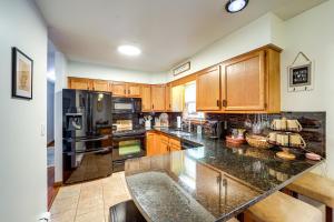 a kitchen with wooden cabinets and a granite counter top at Walk to Owasco Lake Auburn Home with Hot Tub in Auburn