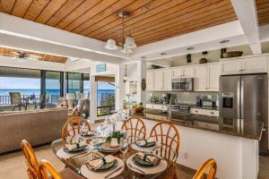 カハナにあるKahana Village 33 · KHV 33 Oceanfront 2BD Villa Spectacular Oceaのテーブルと椅子のあるキッチンとダイニングルーム