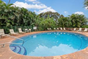 Una gran piscina azul con sillas y árboles. en Kaanapali Plantation 18 · KPL 18: Ocean views, beach nearby, com, en Lahaina