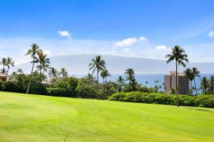 a golf course with palm trees and the ocean at Kaanapali Plantation 10 · KPL 10 Panoramic Ocean Views 2BD near in Lahaina