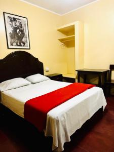 a bedroom with a large bed with a red blanket at Hotel Palacios in Tingo María