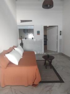 a bedroom with a bed with white pillows and a table at playa pescador apart hotel in Santa Fe +21 photos