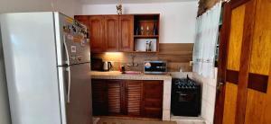 a kitchen with a white refrigerator and wooden cabinets at Casa Hogar-Barbacoa y Garaje in Salto