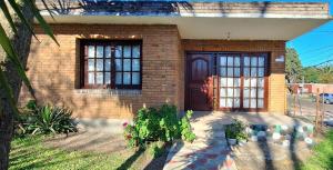 a brick house with a brown door and windows at Casa Hogar-Barbacoa y Garaje in Salto
