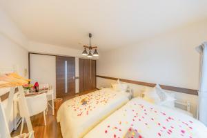 une chambre avec un lit, un bureau et une table dans l'établissement オーシャンビュー窓から見える景色を思い出に the琉球タワー10E, à Yonabaru