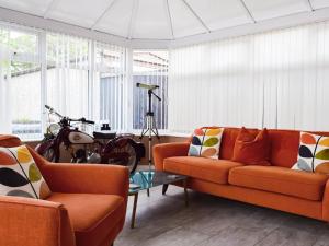 a living room with a couch and a motorcycle parked in it at Pinecote in Bottesford