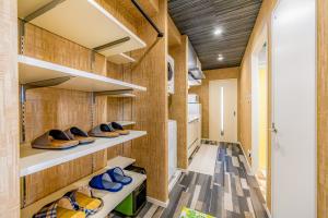 Una habitación con paredes de madera y estantes con zapatos. en オーシャンビュー窓から見える景色を思い出に The琉球タワー 10D, en Yonabaru
