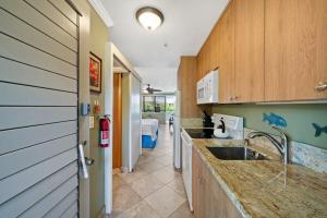 a kitchen with a sink and a room with a bed at Napili Bay 210 · NB 210 Napili Bay Studio with Direct Ocean View in Kahana