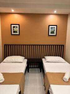 two beds in a room with a wall at Marianne Home Inn - PPC in Puerto Princesa City +11 photos