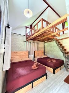 two beds in a room with a staircase at Eve house koh kood in Ko Kood
