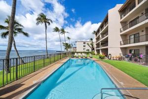 a swimming pool with a view of the ocean at Lauloa 403 · LOA 403 Fully Remodeled Direct Oceanfront 2BD in Wailuku