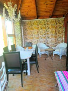 een eetkamer met tafels en stoelen en een stenen muur bij Las Rosas in Pollos