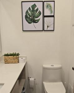 bagno con servizi igienici e 3 immagini sul muro di Loft BelloHorizonte vista al mar y reserva cabo tortuga a Santa Marta