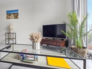 a living room with a tv and a glass table at Oasis in Hythe