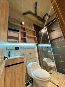 a bathroom with a toilet and a glass shower at Our Home Granada in Cali