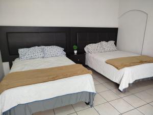 two beds sitting next to each other in a room at Tlaxcala Apartment # 4 in Ciudad Obregón