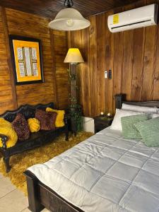 une chambre avec un lit et un canapé dans l'établissement Cabaña acogedora a 20min de la Fortuna, à Ángeles
