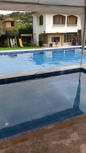 a large swimming pool with blue water in front of a house at Refugio in Hacienda Chaquibamba