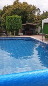 a large blue swimming pool with a table at Refugio in Hacienda Chaquibamba