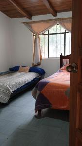 a bedroom with two beds and a window at Refugio in Hacienda Chaquibamba
