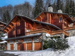 a large wooden house with snow in front of it at Appartement cosy 2 pièces avec wifi à Méribel - FR-1-180-663 in Chandon