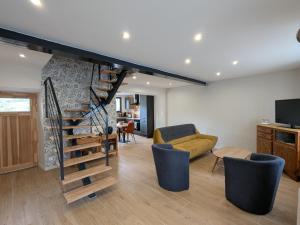 a living room with a spiral staircase and a couch at Maison rénovée avec terrasse et balcon à Polignac - FR-1-582-539 in Saint-Vidal