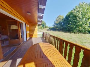 a wooden bench sitting on a porch of a house at Chalet au calme pour 10 pers, proche centre et activités - FR-1-834-9 in Les Rousses