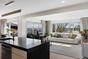 an open kitchen and living room with a couch at Rainbow Haven Where family time meets Lake time in Coffs Harbour