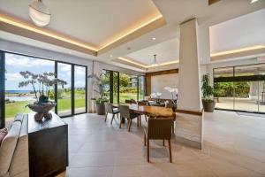 ラハイナにあるWhaler 712 · WHA 712 Kaanapali OceanFront Condo w Ocean Viewsのテーブルと椅子と大きな窓のあるダイニングルーム