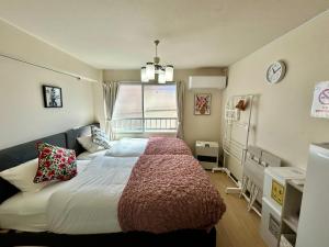 ein Schlafzimmer mit großem Bett und Fenster in der Unterkunft テラ二十四軒 in Sapporo