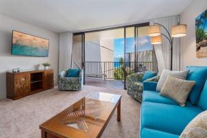a living room with a blue couch and a table at Kaanapali Shores 548 in Kahana