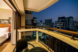 a room with a balcony with a view of the city at Grand Mercure SP Itaim Bibi in Sao Paulo
