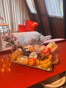 ein Tablett mit Brot und anderen Speisen auf einem Tisch in der Unterkunft Chalé de Luxo em São Pedro de Alcântara - SC in São Pedro de Alcântara