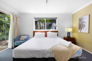 a bedroom with a large bed and a window at Diggers Beach Studio in Kororo Basin