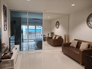 a living room with two couches and a clock on the wall at Condo Baan klang Hua Hin city center in Hua Hin