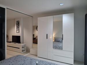 a bedroom with a large white cabinet with a bed at Condo Baan klang Hua Hin city center in Hua Hin