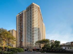 a tall building with many windows in a city at Feifan International Hotel in Guangzhou