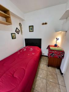 a bedroom with a red bed and a table at Private Cozy room with batroom in Miraflores in Lima +16 photos