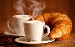 two cups of coffee and a croissant and coffee beans at B&B RoMa Atella in Atella