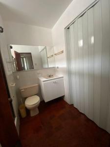 a bathroom with a toilet and a sink and a mirror at Jardines del mar in Santa Elena