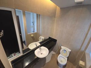 a bathroom with a sink and a toilet and a mirror at Save Hotel เซฟ โฮเทล in Chon Buri