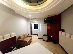 a living room with a couch and a tv on a ceiling at Save Hotel เซฟ โฮเทล in Chon Buri +54 photos