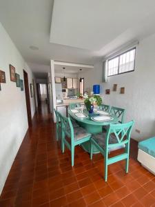 a green table and chairs in a room with a kitchen at Jardines del mar in Santa Elena
